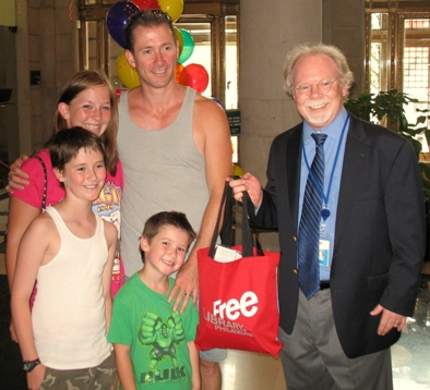 Louis Baker and his children Alyssa (15), Eric (9), and Christopher (4) pose for a photo with Director of Library Operations Joe McPeak.